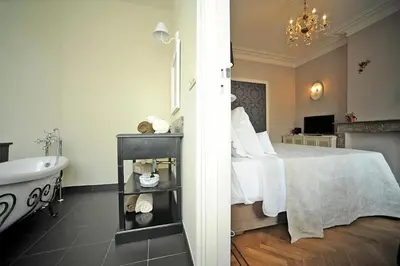 a bedroom with a bed and a tub and a sink at Guesthouse Expo 13 in Ghent