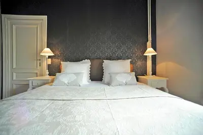 a bedroom with a large white bed with two lamps at Guesthouse Expo 13 in Ghent