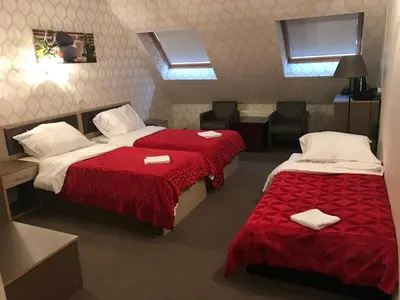 a hotel room with two beds and two chairs at Hotel Rietgors in Temse