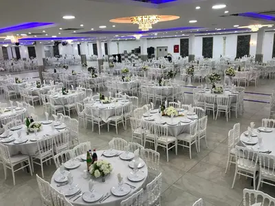 a large banquet hall with white tables and chairs at Hotel Rietgors in Temse