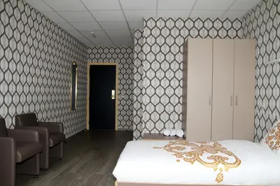 a bedroom with a bed and a room with chairs at Hotel Rietgors in Temse
