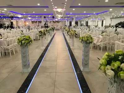 a banquet hall with tables and chairs and vases with flowers at Hotel Rietgors in Temse