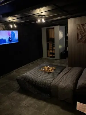 a bedroom with a large bed and a flat screen tv at Privé sauna Hoogstraten in Hoogstraten