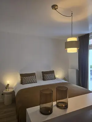 a bedroom with a bed with two glasses on a table at Topgelegen Appartement Alma in Antwerp