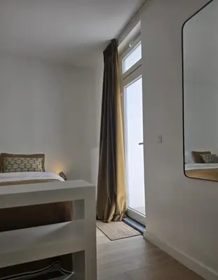 a bedroom with a bed and a window at Topgelegen Appartement Alma in Antwerp