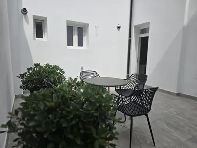 a patio with two chairs and a table and some plants at Topgelegen Appartement Alma in Antwerp