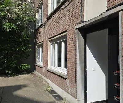 a brick building with a white garage door on it at Topgelegen Appartement Alma in Antwerp