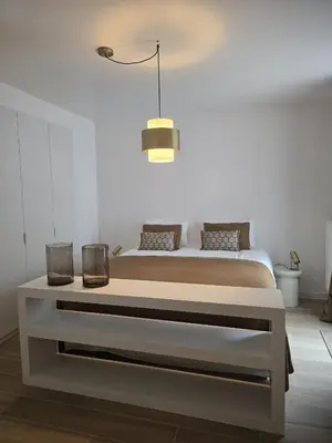a white bedroom with a bed and a table at Topgelegen Appartement Alma in Antwerp