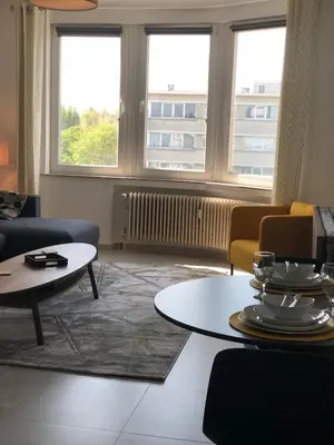 a living room with couches and tables and windows at Studio 30 Pied a terre in Brussels
