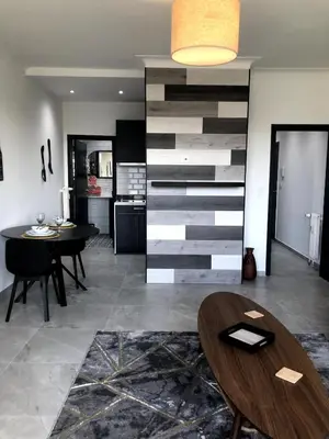 a living room with a table and a wall at Studio 30 Pied a terre in Brussels