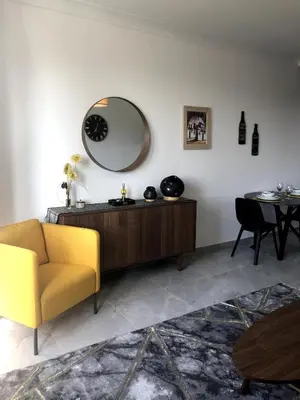a living room with a yellow chair and a mirror at Studio 30 Pied a terre in Brussels