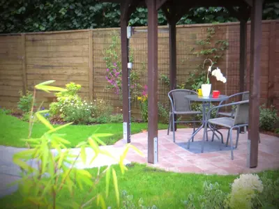 a patio with chairs and a table in a garden at Bed and breakfast Mentari in Ghent