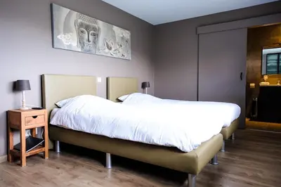 a bedroom with two beds and a nightstand and a skull picture at Bed and breakfast Mentari in Ghent