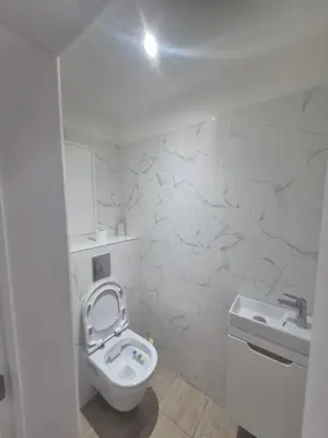 a white bathroom with a toilet and a sink at Genius BNB Buyl 2BR Terrace Near City Center Brussels in Brussels