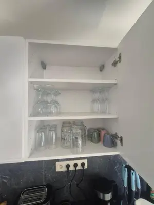 a kitchen with a counter with glasses on shelves at Genius BNB Buyl 2BR Terrace Near City Center Brussels in Brussels