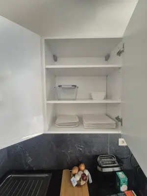 an open refrigerator with shelves and a wooden table at Genius BNB Buyl 2BR Terrace Near City Center Brussels in Brussels