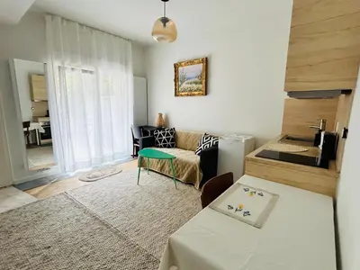 a living room with a couch and a table at Cosy small studio in Brussels