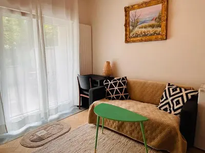 a living room with a couch and a table at Cosy small studio in Brussels