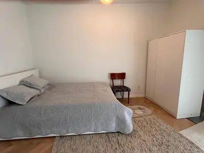 a bedroom with a bed and a chair at Cosy small studio in Brussels