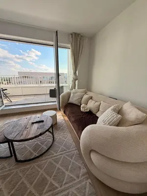 a living room with a couch and a large window at Séjour lumineux avec Balcon in Brussels