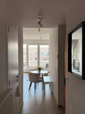 a dining room with a table and a window at Séjour lumineux avec Balcon in Brussels