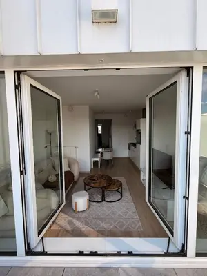 a living room with sliding glass doors and a table at Séjour lumineux avec Balcon in Brussels