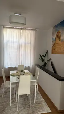 a white dining room with a table and chairs at Cozy appartement in Brussels- Schuman Area in Brussels