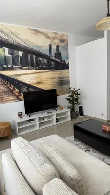 a living room with a tv and a white couch at Cozy appartement in Brussels- Schuman Area in Brussels