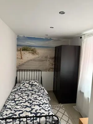 a bedroom with a bed and a painting of a beach at Cozy appartement in Brussels- Schuman Area in Brussels