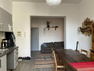 a kitchen and living room with a table and a couch at Appartement Saint-Gilles in Brussels