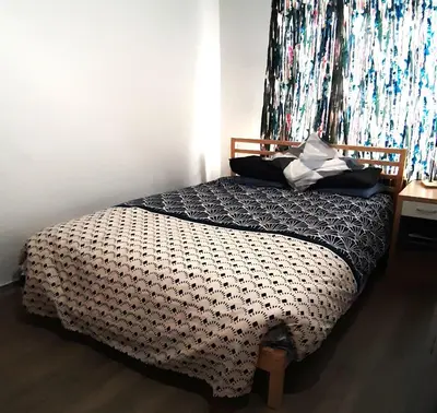 a bedroom with a bed with a black and white comforter at Appartement Saint-Gilles in Brussels