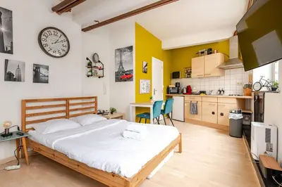 a bedroom with a bed and a clock on the wall at Cosy studio in the heart of Brussels - Grand place in Brussels