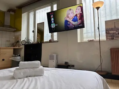 a bedroom with a bed with a flat screen tv on the wall at Cosy studio in the heart of Brussels - Grand place in Brussels