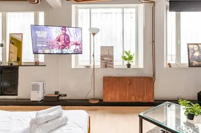 a living room with a flat screen tv on the wall at Cosy studio in the heart of Brussels - Grand place in Brussels