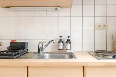 a kitchen sink with two bottles on a counter at Cosy studio in the heart of Brussels - Grand place in Brussels