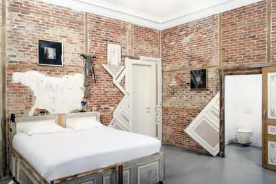 a bedroom with a brick wall and a bed at B&B DRUUM in Brussels