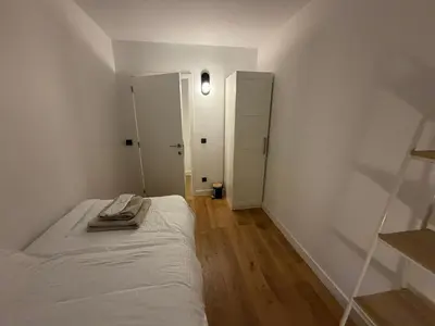 a white bedroom with a bed and a closet at businessflat mol center in Mol