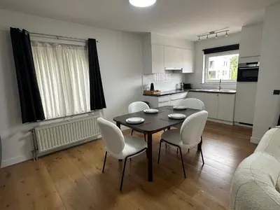 a living room with a table and chairs and a kitchen at businessflat mol center in Mol