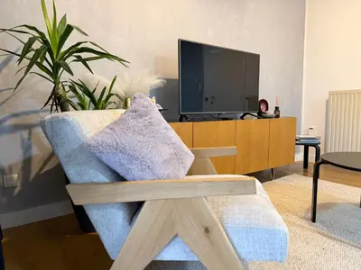 a living room with a chair and a tv at businessflat mol center in Mol