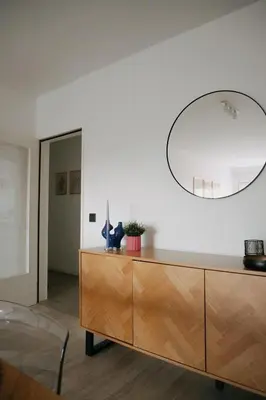 a living room with a wooden dresser and a mirror at Casa Congé - Colorful Stay & Free Wine Bottle in Mechelen