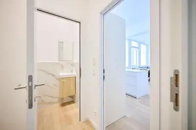 a white bathroom with a mirror and a sink at Louise City Center in Brussels