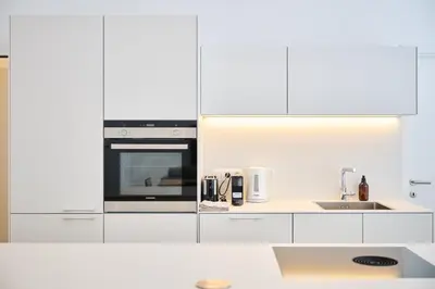 a white kitchen with a sink and a microwave at Louise City Center in Brussels