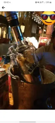 a bottle of wine in a bucket on a table at Money Home in Ghent