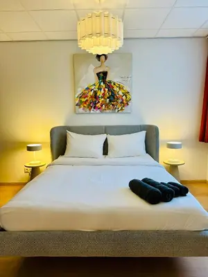 a bedroom with a bed with a painting on the wall at Grand Place - Prime Location 2 Bedroom Apartment in Brussels