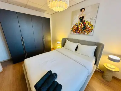 a bedroom with a large white bed with a dresser at Grand Place - Prime Location 2 Bedroom Apartment in Brussels