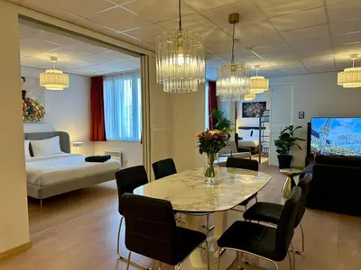 a living room with a table and a bedroom at Grand Place - Prime Location 2 Bedroom Apartment in Brussels