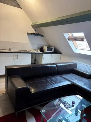 a living room with a black leather couch in a kitchen at Marie home in Brussels