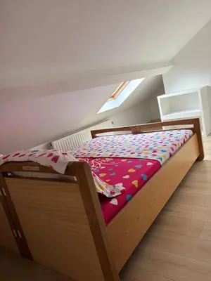 a bedroom with a wooden bed with a colorful comforter at Marie home in Brussels