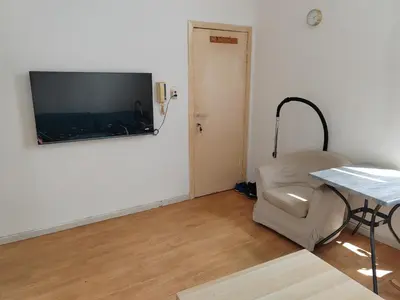 a living room with a table and a television on the wall at Belgie in Ghent