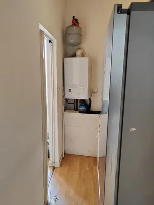 a hallway with a door open to a room with a refrigerator at Belgie in Ghent